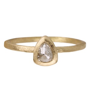 May include: A gold ring with a pear-shaped diamond set in a bezel setting.
