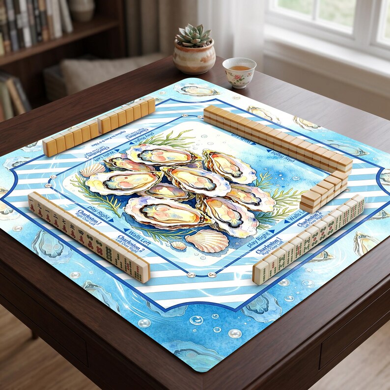 May include: A Mahjong game set with wooden tiles and a blue and white oyster-themed playing surface. The surface features illustrations of oysters, seashells, and text that reads "Charleston" and "Play Right".