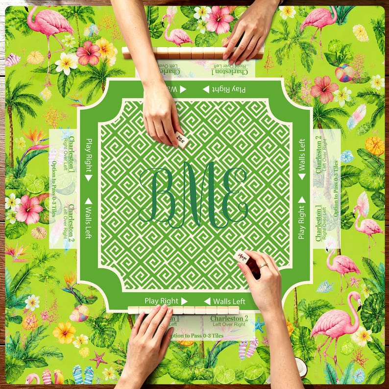 K&ouml;nnte beinhalten: Eine quadratische Mahjong-Matte mit einem leuchtend gr&uuml;nen Tropenmuster, rosa Flamingos, Hibiskusbl&uuml;ten und Palmbl&auml;ttern. Die Mitte hat einen wei&szlig;en geometrischen Rand mit dem Monogramm BME. Text enth&auml;lt Play Right, Walls Left und Charleston.