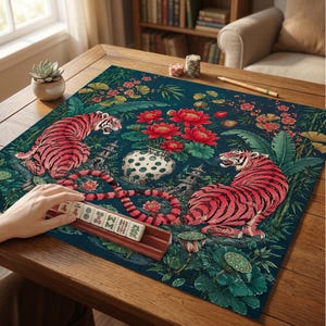 Puede incluir: Un tapete de mahjong cuadrado con fondo verde azulado oscuro, dos tigres rosas, flores de loto rojas, un jarr&oacute;n blanco con lunares y pagodas de piedra. Un soporte de madera sostiene seis fichas de mahjong con caracteres chinos.