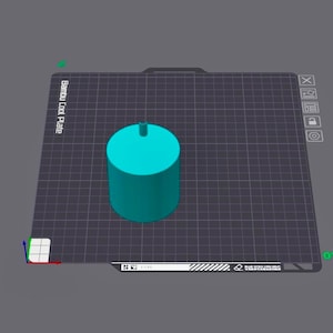 May include: A teal cylindrical object with a small, raised cylinder on top. The object is on a dark grey surface with a grid pattern. The words "Bambu Cool Plate" are visible.