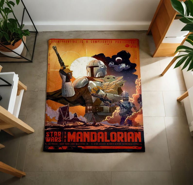 Może przedstawiać: Prostokątny dywan Star Wars: The Mandalorian z projektem w stylu plakatu. Grafika przedstawia Mandalorianina trzymającego broń, z Grogu i innymi postaciami na tle zachodu słońca. Dywan ma czerwoną obw&oacute;dkę ze słowami "Star Wars" i "Mandalorian".
