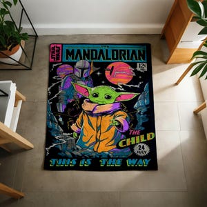 Może przedstawiać: Prostokątny czarny dywan z komiksowym wzorem z napisem "The Mandalorian" i "The Child". Obraz zawiera zieloną postać z dużymi uszami, postać w zbroi i kolorowe planety.