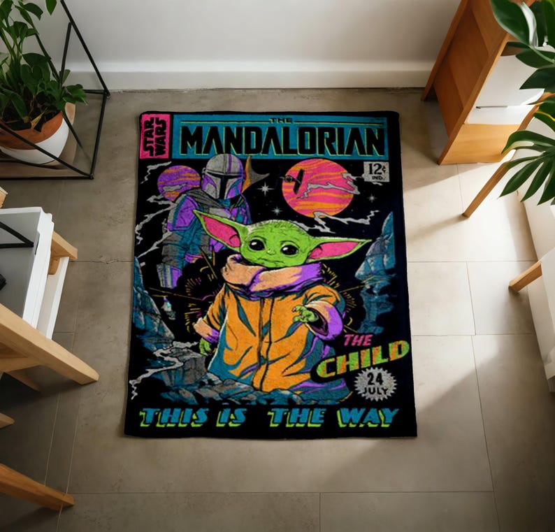 Może przedstawiać: Prostokątny czarny dywan z komiksowym wzorem z napisem "The Mandalorian" i "The Child". Obraz zawiera zieloną postać z dużymi uszami, postać w zbroi i kolorowe planety.