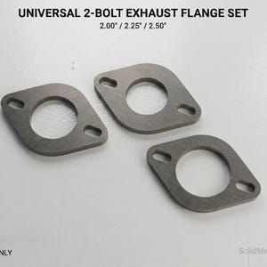 Puede incluir: Tres juegos de bridas de escape universales de 2 pernos. Las bridas son de metal gris y tienen forma rectangular con esquinas redondeadas. Cada brida tiene un gran orificio central y dos orificios para pernos más pequeños. El texto "UNIVERSAL 2-BOLT EXHAUST FLANGE SET" está en la parte superior.