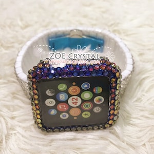 Pode incluir: Uma caixa de pulseira de relógio com joias azuis, roxas e laranja para um Apple Watch. O mostrador do relógio é visível e mostra a hora 4:42. O texto "ZOE CRYSTAL http://zoecrystal.com" é visível na caixa.