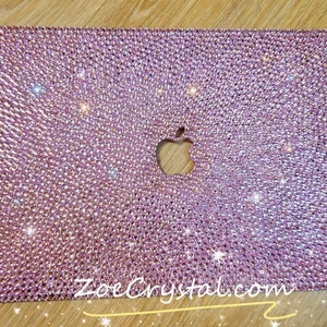 May include: A pink laptop cover with a sparkly, crystal-like design. The Apple logo is cut out of the cover. The text "ZoeCrystal.com" is visible in the bottom right corner.