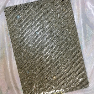 Könnte beinhalten: Eine silberne, glitzernde iPad-Hülle mit dem Text "ZoeCrystal.com" in der unteren rechten Ecke.