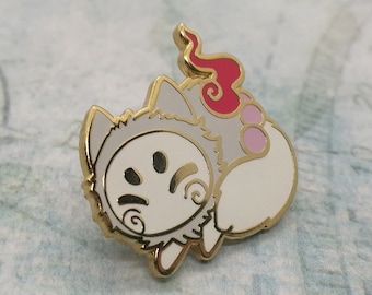 May include: A white enamel pin with a cartoon fox wearing a white mask with a red flame on its tail. The fox has pink accents on its body.