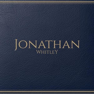 以下が含まれることがあります： 紺色の革のような質感の表面に、金色の文字で「JONATHAN WHITLEY」と書かれています。 デザインは細い金の縁で囲まれ、クラシックでエレガントな美しさを醸し出しています。