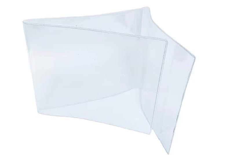 May include: A clear, transparent plastic wallet, open to display its interior. The wallet has a simple, minimalist design, with clean lines and a folded construction. The material appears to be thin and flexible.