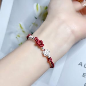 Könnte beinhalten: Eine weiße Keramik-Tasse mit schwarzem Henkel und dem Text "But First, Coffee" in fetter, schwarzer Schrift. Die Tasse steht vor einem verschwommenen Hintergrund, der ihr klares Design hervorhebt.