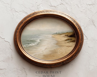 May include: An oval framed print of a beach scene. The artwork shows a sandy beach, ocean waves, and a cloudy sky. The frame is a detailed gold colour. The text "CEDAR PRINT HOUSE" is at the bottom of the frame.