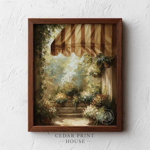 May include: A framed print of a garden scene with a striped awning. The artwork depicts a stone staircase, lush greenery, and potted flowers. The frame is a dark brown color, and the text "CEDAR PRINT HOUSE" is at the bottom.