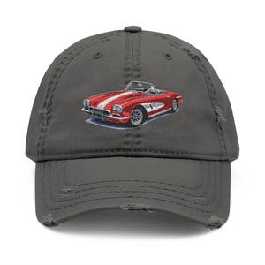 May include: Distressed charcoal gray baseball cap featuring an embroidered red convertible car with white stripes. The cap has a pre-worn look with distressed details on the brim and crown. A classic car design.