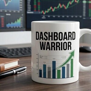 Può includere: Una tazza in ceramica bianca con il testo nero DASHBOARD WARRIOR sopra un grafico a barre colorato con una freccia verde rivolta verso l'alto. La tazza ha un manico standard ed è posizionata in verticale, mostrando chiaramente il disegno.