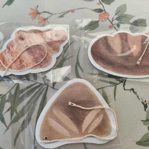 May include: A set of three ceramic nesting bowls in graduating sizes. The bowls are white with a speckled, textured finish and feature a slightly flared rim. The largest bowl is approximately 20 cm in diameter.