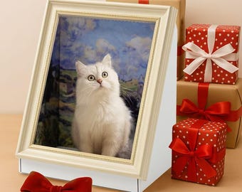 May include: A white cat with green eyes is framed in a cream-colored picture frame, set on a white base. The background in the frame is a landscape painting. Red gift boxes with white bows and a red velvet bow are also present.