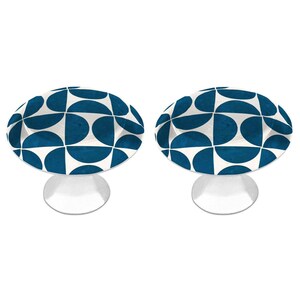 May include: A pair of circular pedestal bowls featuring a repeating geometric pattern of dark blue semicircles on a white background. Each bowl has a wide, shallow basin and a solid, flared white base that supports the elevated circular top.