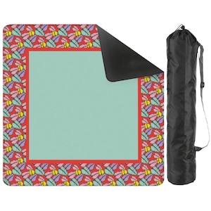 May include: A colorful picnic blanket with a red border and a pattern of multi-colored butterfly-like shapes. The center is a solid light green. A black carrying bag with a shoulder strap is included.