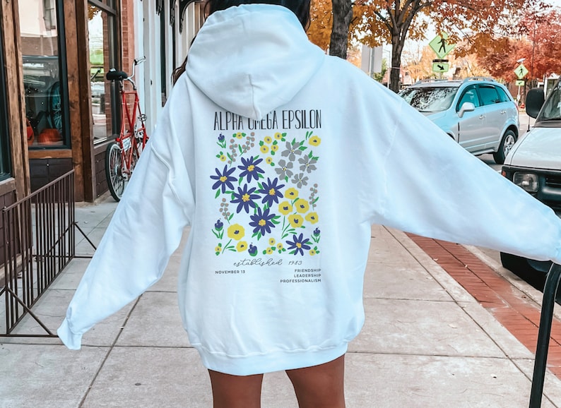 May include: White hooded sweatshirt with a floral design and the text "Alpha Omega Epsilon established 1943 November 13 Friendship Leadership Professionalism" printed on the back.