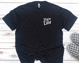 May include: Black t-shirt with white text that reads "Praise the Lord" in a gothic font.
