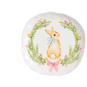 May include: White ceramic plate featuring a watercolour illustration of a bunny with a blue bow, encircled by a floral wreath. A pink bow is at the bottom. A small wooden spreader with a pink flower top is next to the plate.
