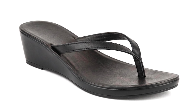 Op de afbeelding: Zwarte teenslippers met sleehak. Deze sandalen hebben een donkere zool en een teenband. De sleehak meet ongeveer 5 cm.