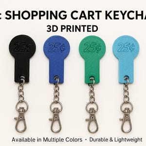 May include: Four 3D-printed shopping cart keychains in black, blue, green, and light blue. Each keychain has a 25¢ coin design and a metal clasp. The text reads "25¢ SHOPPING CART KEYCHAIN 3D PRINTED".
