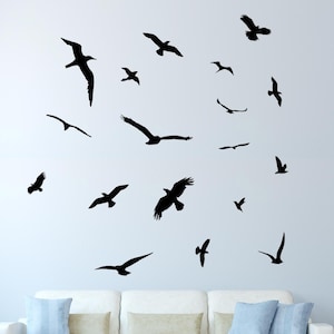 May include: A wall decal featuring a flock of black birds in flight. The birds are silhouetted against a white wall.