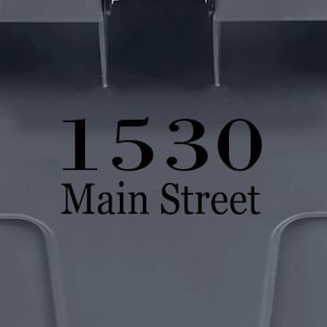 May include: A gray trash can with a black address sticker that says "1530 Main Street".