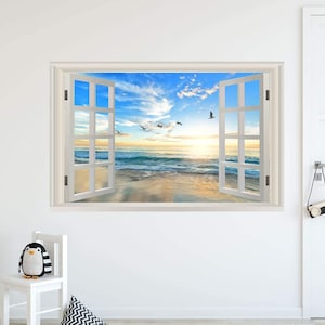 May include: A white window frame with a view of a beach scene. The window is open and the ocean is visible in the distance. The sky is blue with white clouds and there are birds flying in the sky.