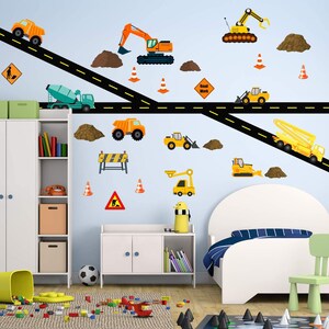 May include: A set of construction vehicle wall decals featuring a variety of vehicles, including excavators, dump trucks, and cement mixers. The decals are yellow and orange and are set against a blue wall with a black road and brown dirt piles. The decals are perfect for a child's room or playroom.