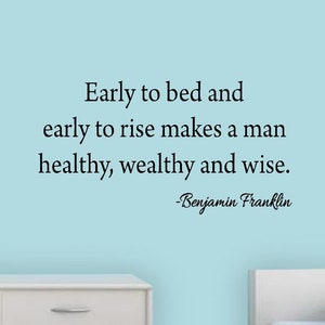 Peut inclure: Un mur bleu clair avec une citation en texte noir qui dit "Early to bed and early to rise makes a man healthy, wealthy and wise." La citation est attribuée à Benjamin Franklin. Le mur est décoré d'une commode blanche et d'un lit blanc.