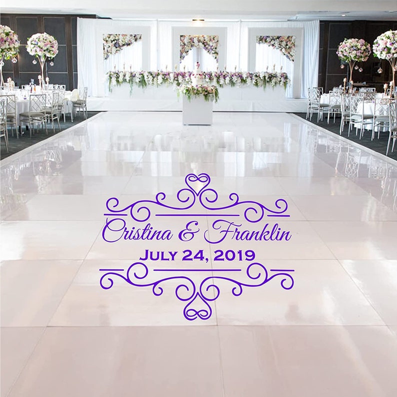 May include: A white dance floor with a purple wedding announcement that reads "Cristina & Franklin JULY 24, 2019" with a decorative heart and scroll design.