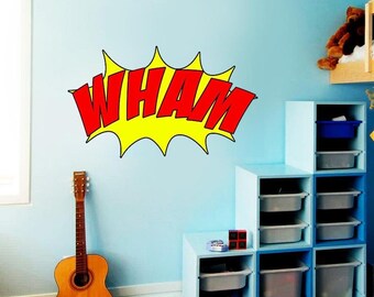 May include: A yellow and red comic book style "WHAM" sound effect decal on a light blue wall. The decal is in a burst shape with a yellow background and red letters.