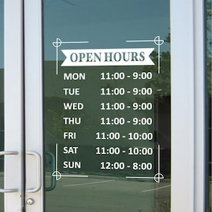 May include: White vinyl decal on a glass door displaying business hours. The text "OPEN HOURS" is above a list of days and times: Mon-Thu 11:00-9:00, Fri-Sat 11:00-10:00, and Sun 12:00-8:00. Decorative lines and flourishes frame the text.