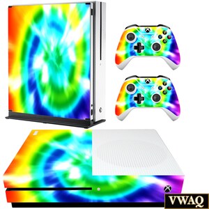 May include: A tie-dye skin decal for the Xbox One console and two controllers. The decal features a swirling pattern of blue, green, yellow, and orange.