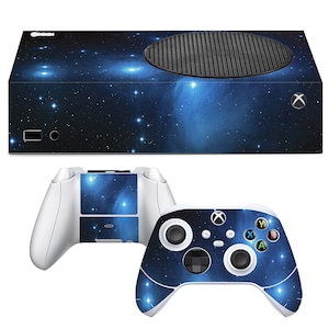 May include: A white Xbox Series X console and controller with a blue and black galaxy design. The console has a black grill on the top and a white Xbox logo on the front. The controller has a white body with a blue and black galaxy design on the front and back.
