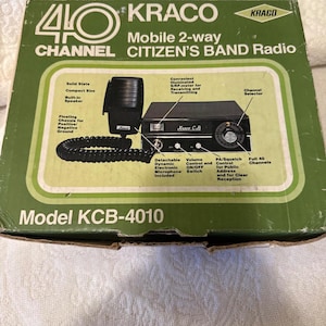 May include: Vintage Kraco KCB-4010 mobile 2-way Citizens Band radio in its original box. The box features a green and white design with product details, including a detachable microphone and channel selector. The radio is a solid-state, compact size.