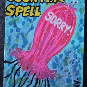 Puede incluir: Una tarjeta pintada a mano con las palabras "COUNTER SPELL" en amarillo y negro. Una criatura rosa con forma de medusa con la palabra "SORRY!" en blanco está centrada. Tentáculos negros se extienden de la criatura, sobre un fondo azul.