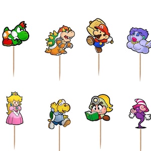 May include: A set of twelve decorative food picks featuring colorful, two-dimensional cartoon character illustrations from the Paper Mario series, including Mario, Luigi, Peach, Bowser, Yoshi, and various other figures, each attached to a thin wooden stick.
