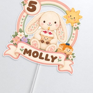 May include: A cake topper featuring a cream-colored bunny holding a small cake, a yellow sun, flowers, and a rainbow arch. The number 5 is displayed in a circle, and a banner at the bottom features the name MOLLY in brown letters on a light pink background.