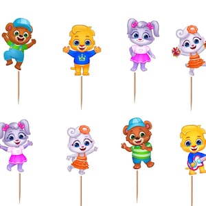 May include: A set of twelve decorative cupcake toppers featuring cartoon characters from Lucas & Friends. The collection includes individual figures of bears, rabbits, and lions, along with two circular logos with the text Lucas & Friends.