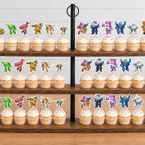 K&ouml;nnte beinhalten: Ein dreist&ouml;ckiger Cupcake-St&auml;nder aus Holz mit zahlreichen Cupcakes, die mit Super Wings-Papieraufsteckern verziert sind. Jeder Cupcake ist mit einem kleinen, bunten Ausschnitt einer animierten Flugzeugfigur auf einem St&auml;bchen versehen.