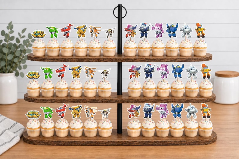 K&ouml;nnte beinhalten: Ein dreist&ouml;ckiger Cupcake-St&auml;nder aus Holz mit zahlreichen Cupcakes, die mit Super Wings-Papieraufsteckern verziert sind. Jeder Cupcake ist mit einem kleinen, bunten Ausschnitt einer animierten Flugzeugfigur auf einem St&auml;bchen versehen.