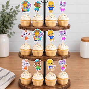 May include: A three-tiered wooden stand holding twelve cupcakes topped with Lucas and Friends character paper toppers. The toppers feature colourful cartoon animals, including a bear, a lion, and a rabbit, with some displaying the text Lucas & Friends.