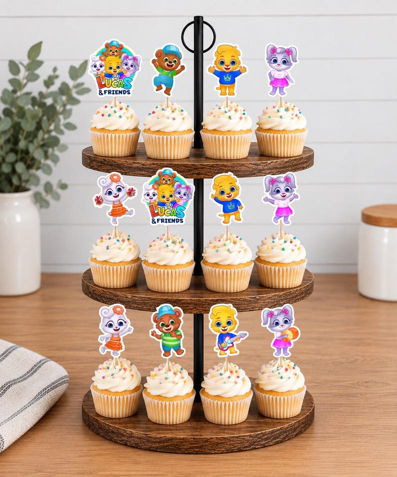 May include: A three-tiered wooden stand holding twelve cupcakes topped with Lucas and Friends character paper toppers. The toppers feature colourful cartoon animals, including a bear, a lion, and a rabbit, with some displaying the text Lucas & Friends.
