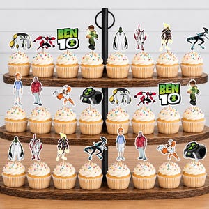 May include: A three-tiered wooden cupcake stand holding twenty-four cupcakes topped with Ben 10 character paper toppers. The toppers feature various alien figures, the Ben 10 logo, and human characters, all printed in full colour on white cardstock.
