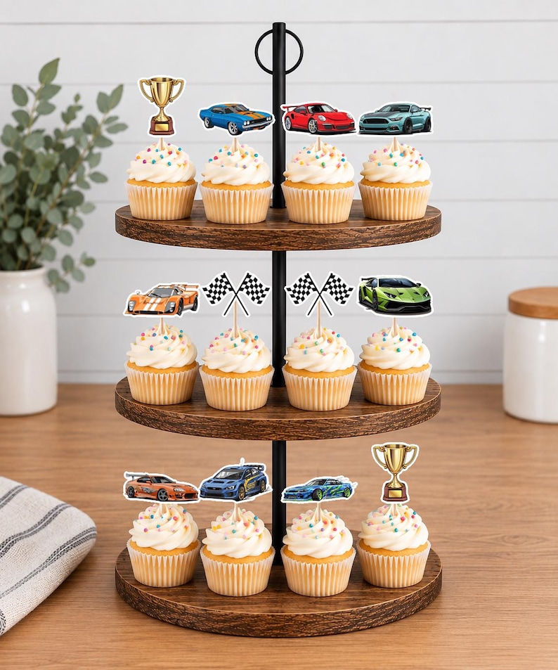 May include: A three-tiered wooden cupcake stand holding twelve cupcakes topped with colorful sprinkles. The cupcakes are decorated with paper toppers featuring various sports cars, checkered racing flags, and gold-colored trophy cups.